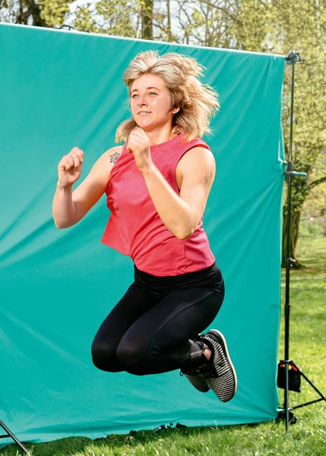 Frau mit Sportkleidung springt in die Höhe