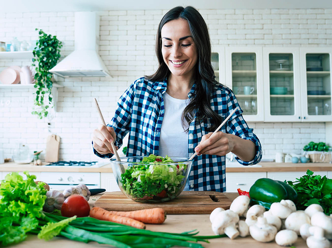 Frau mit einer Schüssel Salat und Salatbesteck