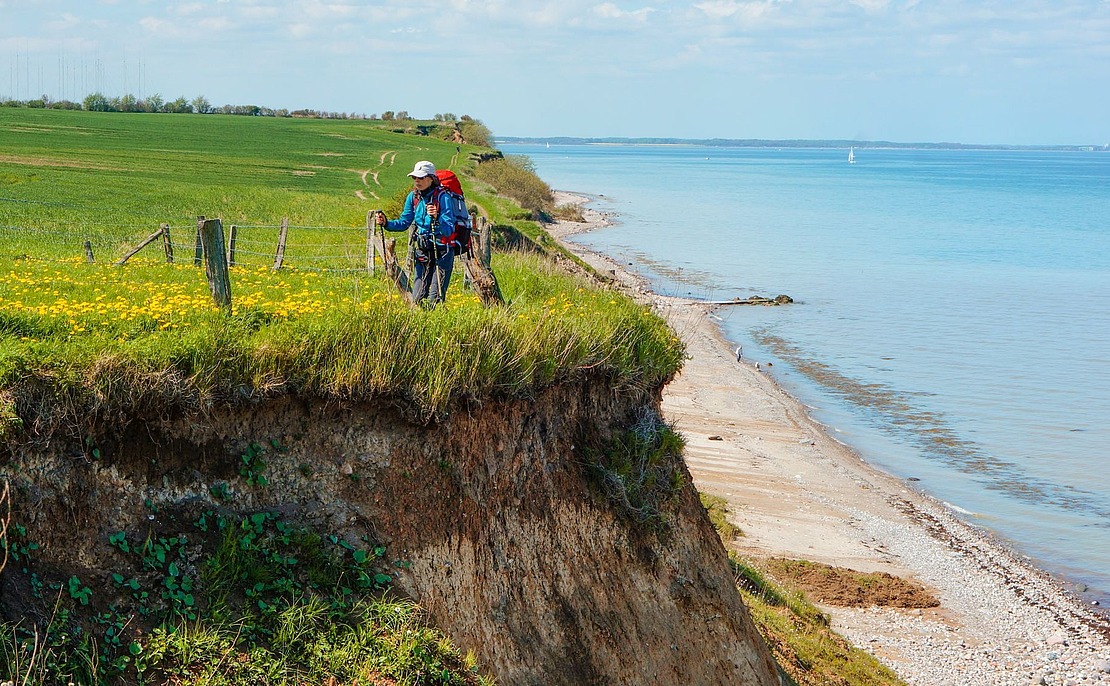 Frau, Marion Riedel, geht an einer Klippe am Meer wandern