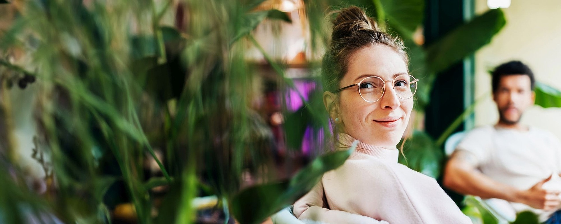 Frau mit Pflanzen, Mann im Hintergrund