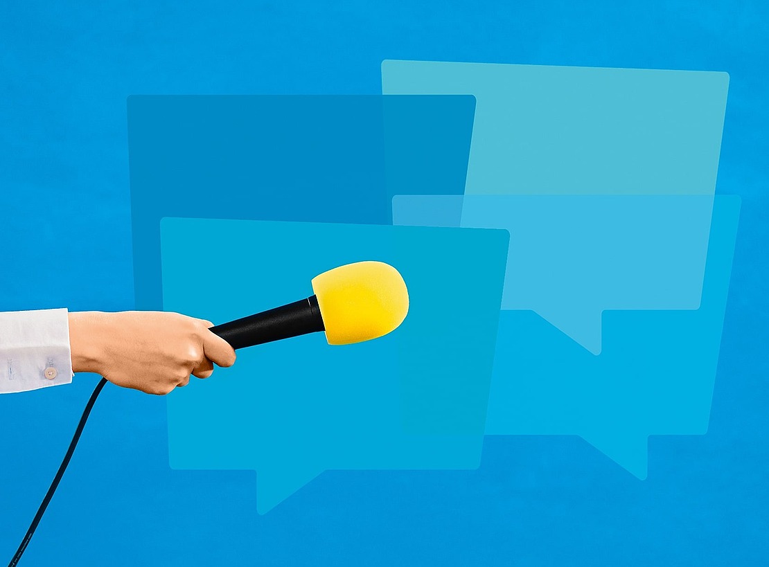 Eine Hand, die ein Mikrofon mit einem gelben Schaumstoffüberzug hält, wird von links vor überlappenden blauen Sprechblasensymbolen auf blauem Hintergrund ausgestreckt.