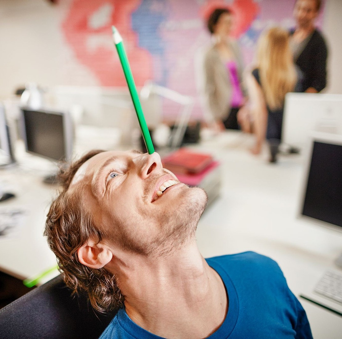 Mann balanciert Stift auf der Nase