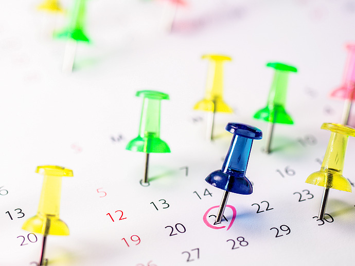 Kalender mit bunten Nadeln