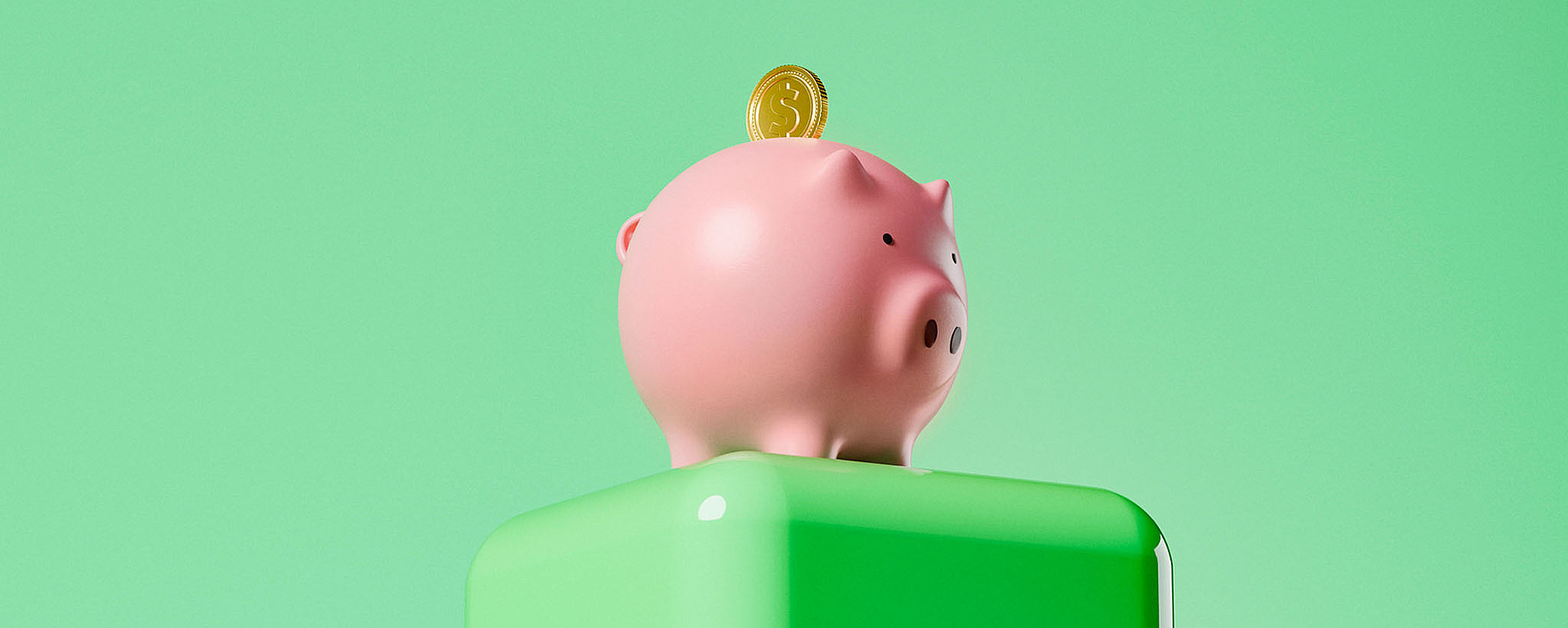 Auf einem glänzend grünen Sockel vor einem einfarbigen hellgrünen Hintergrund steht ein rosa Sparschwein mit einer eingelegten Goldmünze obendrauf.
