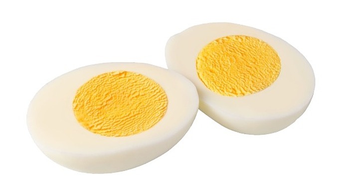 Zwei Hälften eines hartgekochten Eies mit festem Eiweiß und leuchtend gelbem Dotter, dargestellt auf weißem Hintergrund.