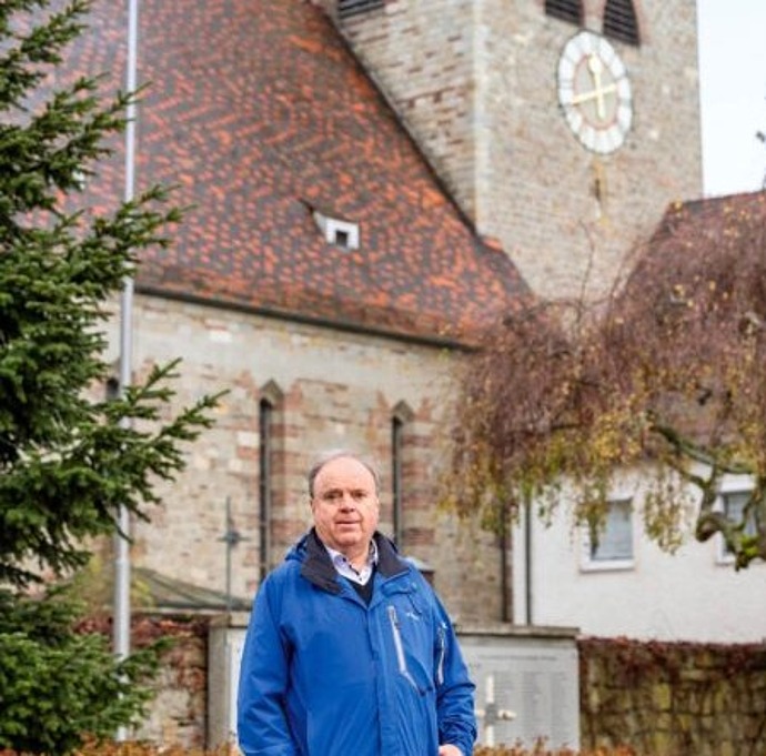 Mann steht vor einer Kirche
