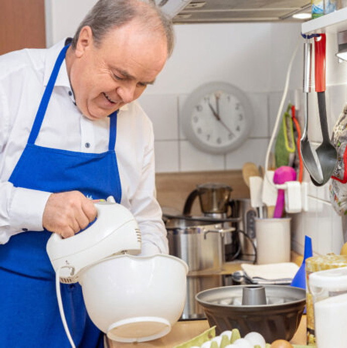 Mann rührt mit Mixer in einer Schüssel