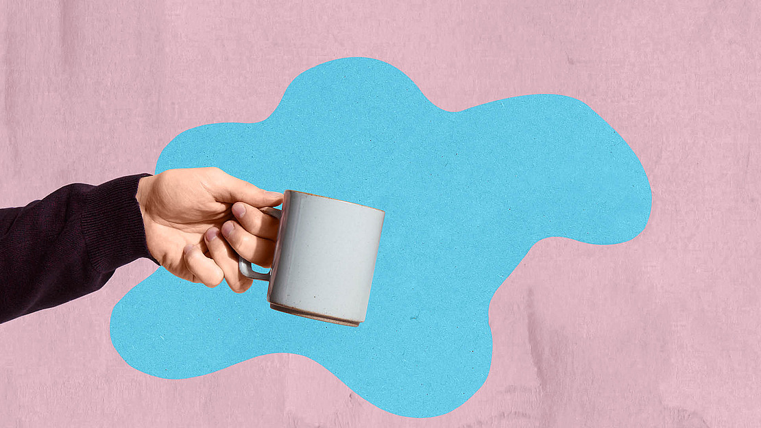 Hand hält eine Tasse