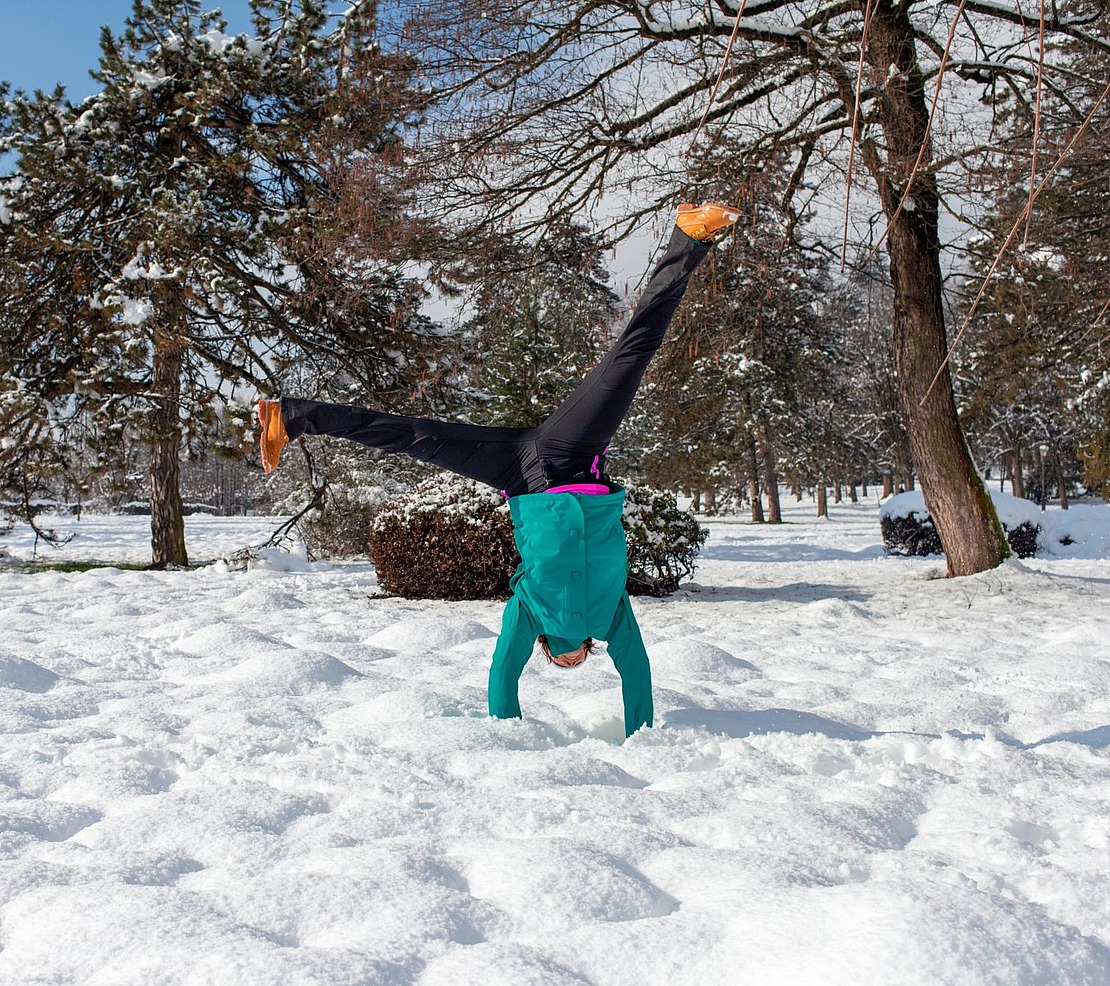 Frau schlägt ein Rad im Schnee